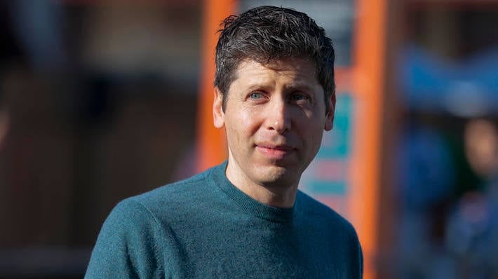OpenAI CEO Sam Altman in a teal sweater, photographed outdoors