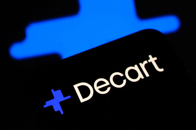 The Decart logo and wordmark in white on a dark smartphone screen with a blurred blue Decart symbol in the background