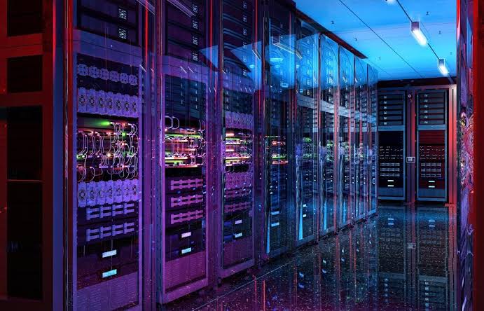 Rows of illuminated data-center server racks, representing Anthropic's compute expansion
