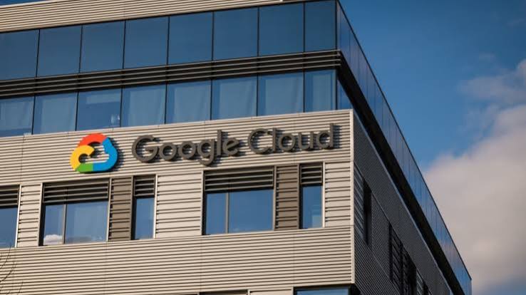 Google Cloud logo and lettering on the facade of an office building with glass windows against a blue sky