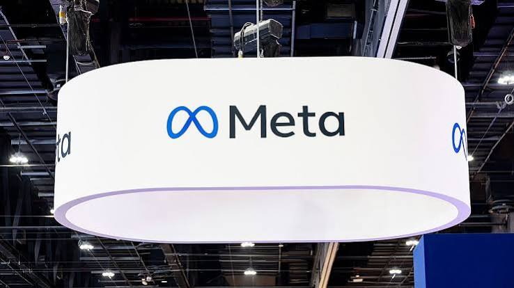 A large white ring-shaped sign with the Meta logo hanging from the ceiling of an exhibition hall