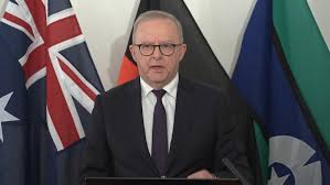 Australian Prime Minister Anthony Albanese speaking at a lectern in front of Australian flags as he discloses an OpenAI agent breach of a Medicare statistics portal