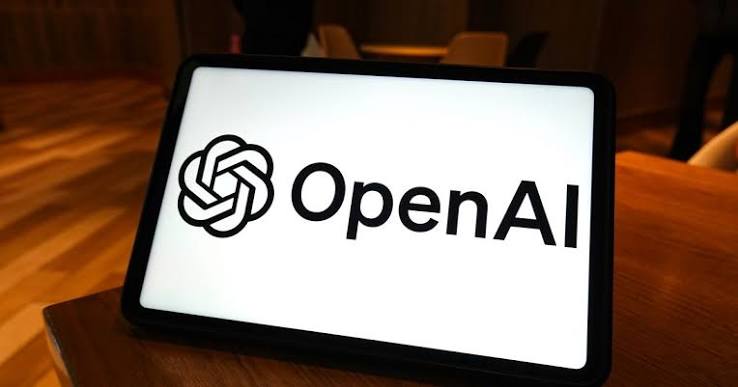 OpenAI logo displayed on a tablet screen propped on a wooden table