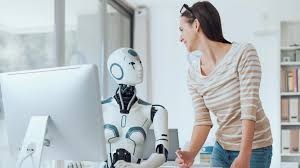 Robot and human collaborating at a computer workstation, representing AI and human working together