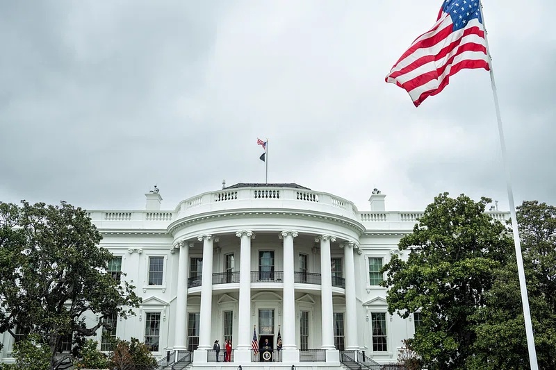 White House South Lawn with the American flag flying on an overcast day
